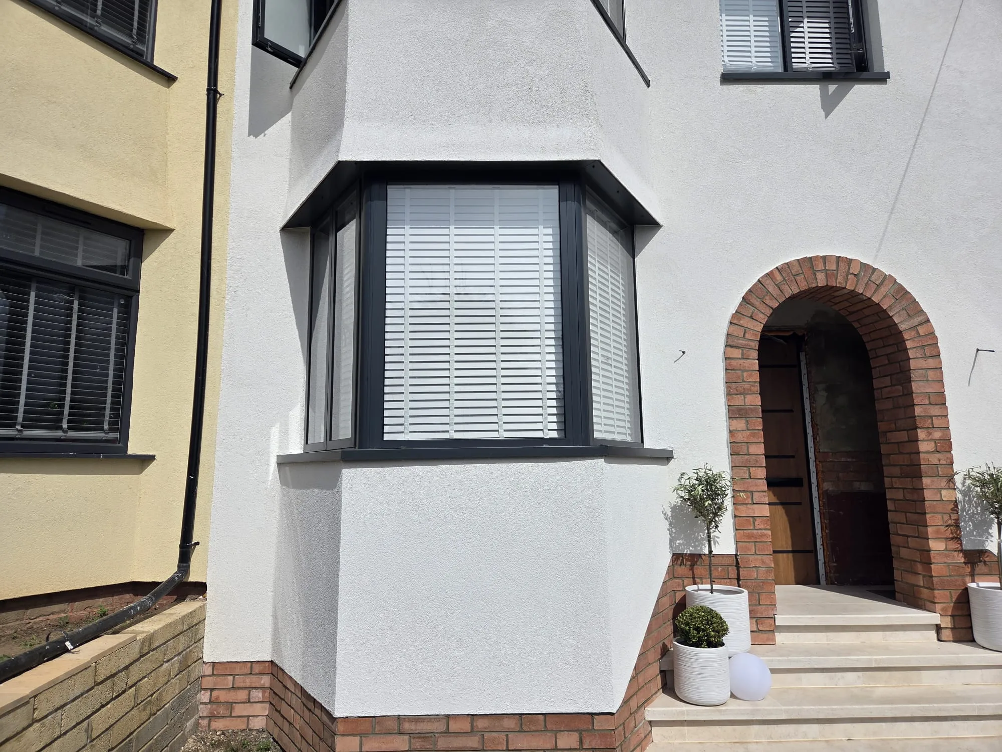 Modern bay window design with white frames and sleek lines, enhancing home aesthetics