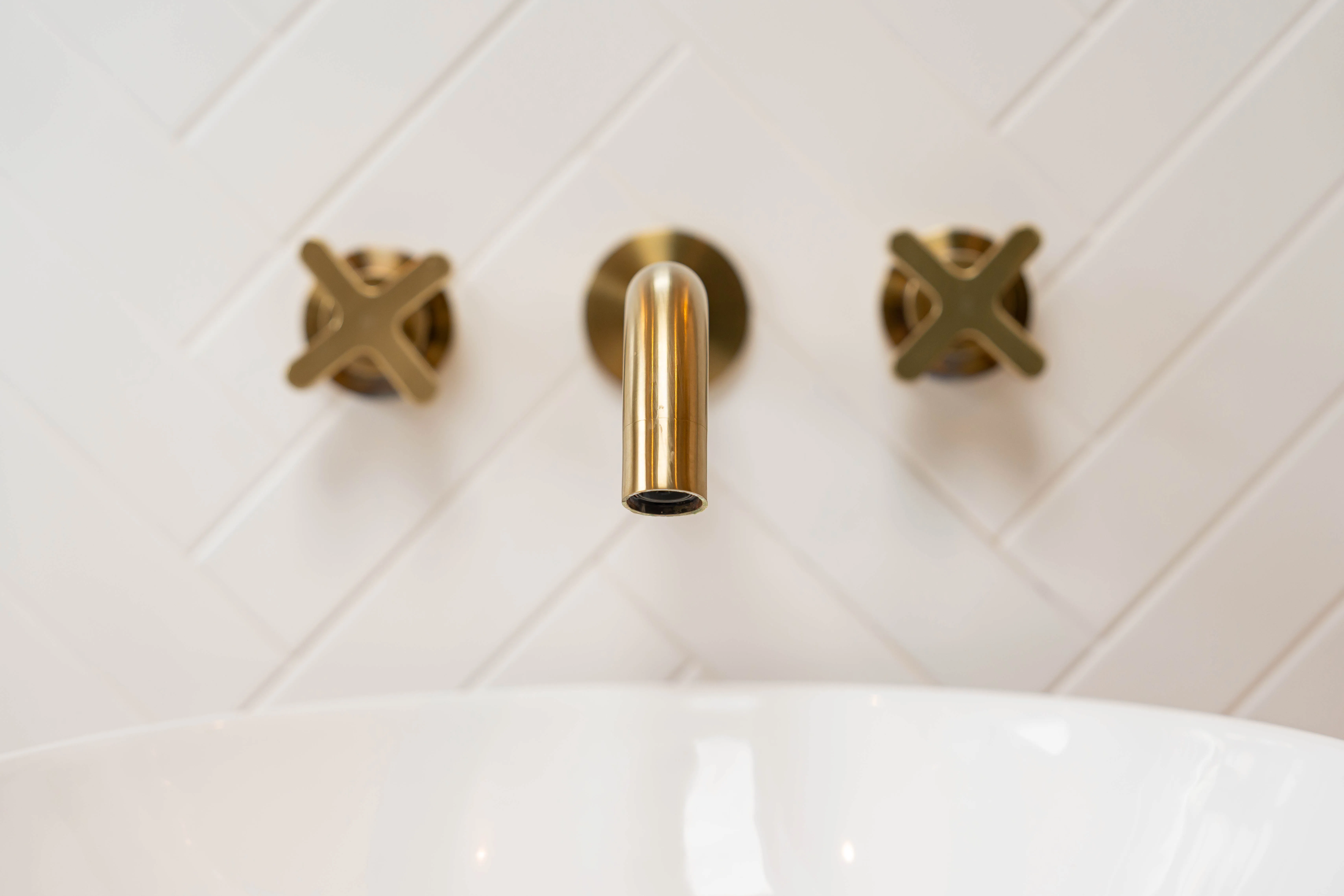 Elegant brass faucet mounted above a white sink in a modern bathroom