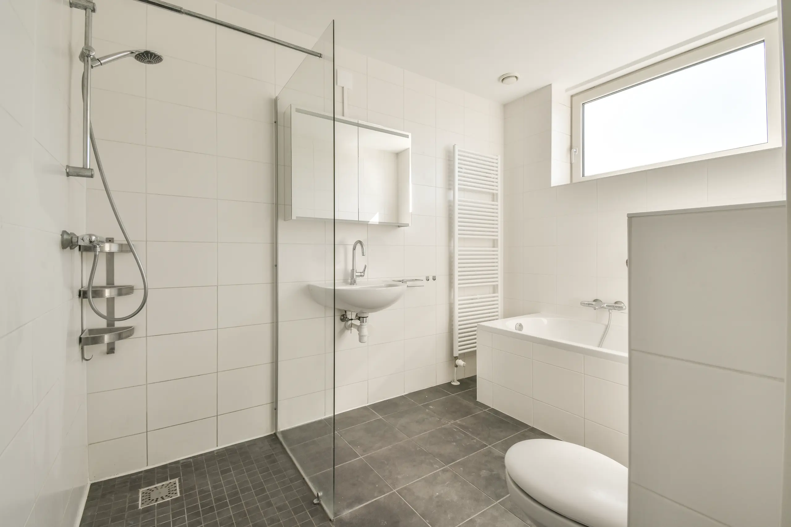Modern bathroom refurbishment featuring a shower, bathtub, and sleek tiles