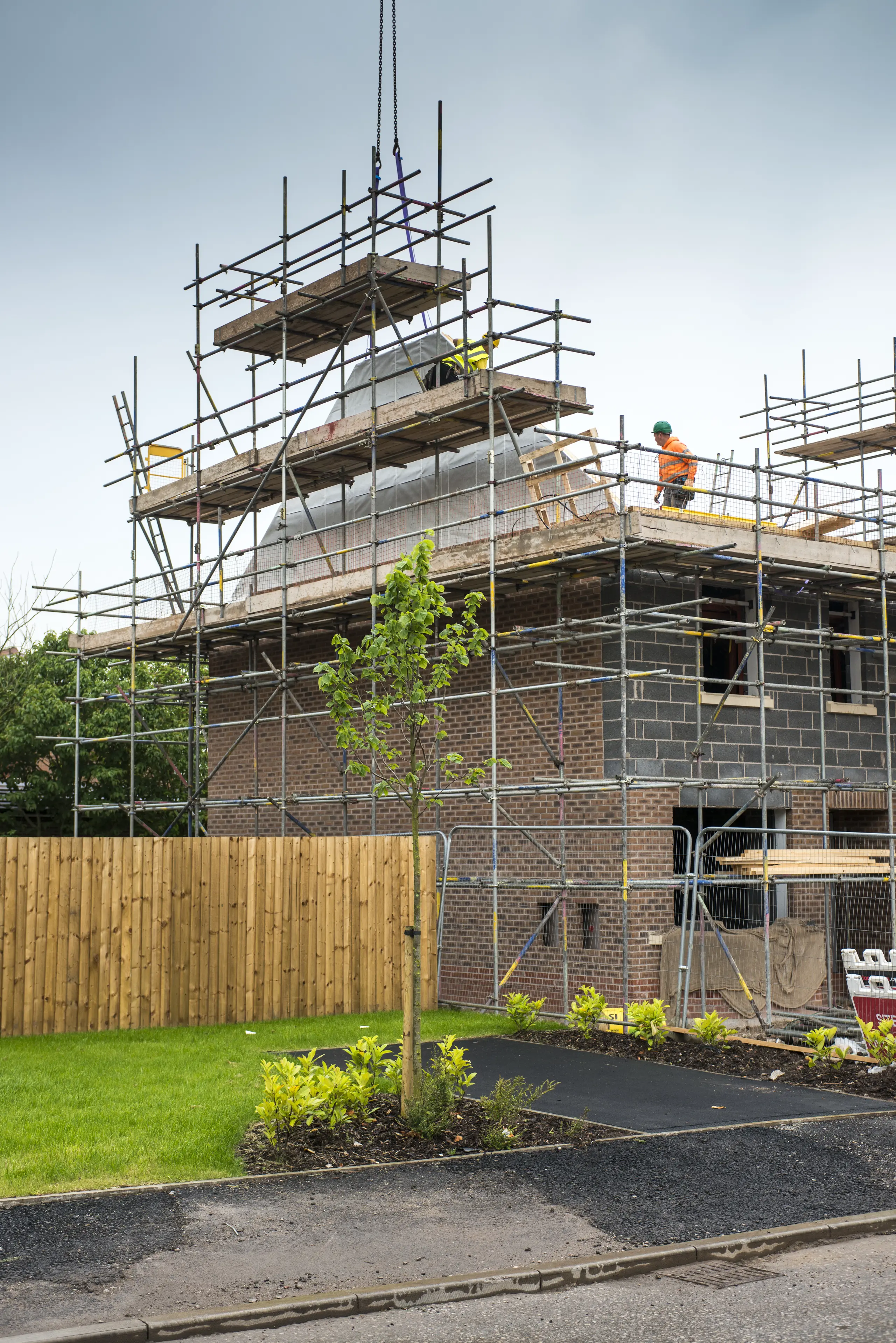 Construction site with scaffolding around a house extension in progress