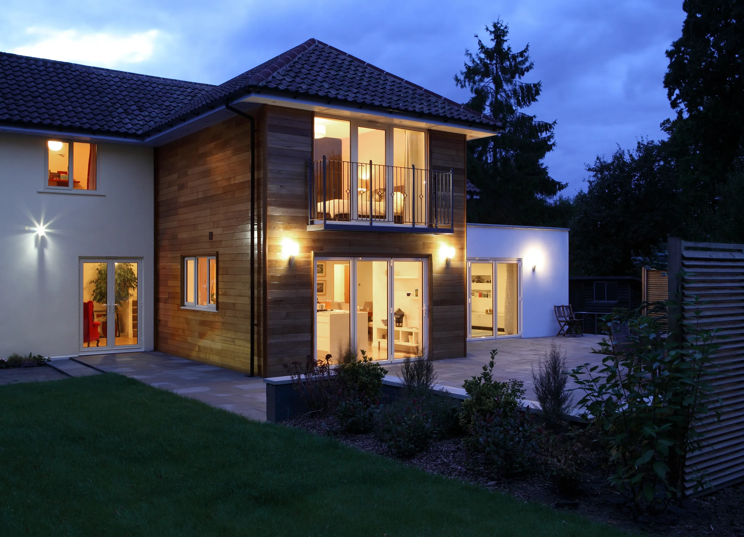 Modern house exterior with garden and patio lighting, showcasing home refurbishment