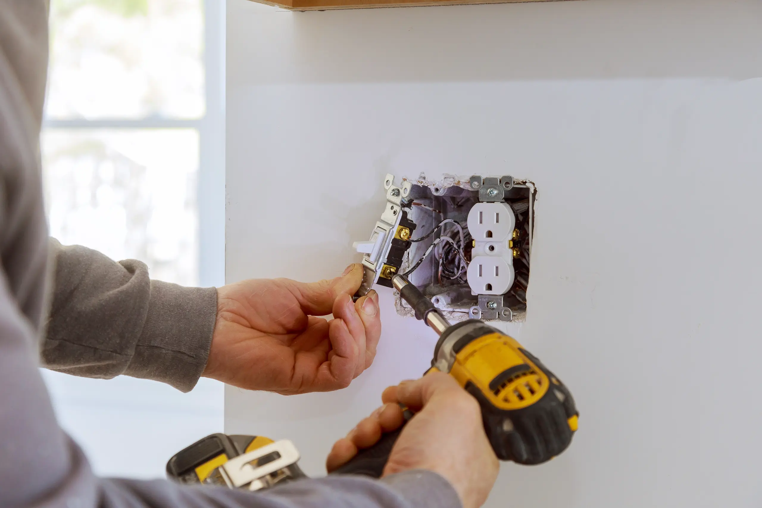 Electrician installing a new electrical outlet in a home refurbishment project
