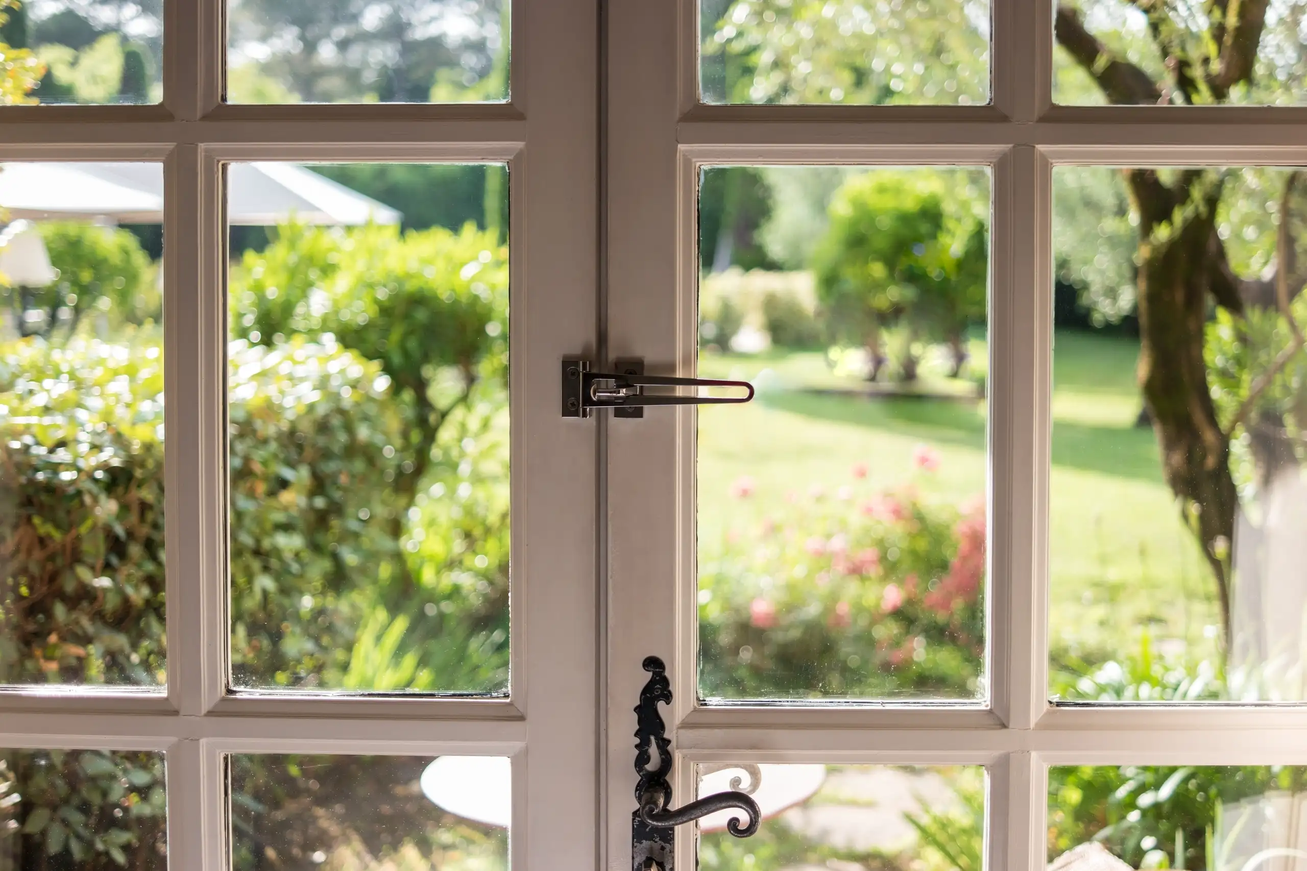 View through a glass door to a green garden, showcasing outdoor space
