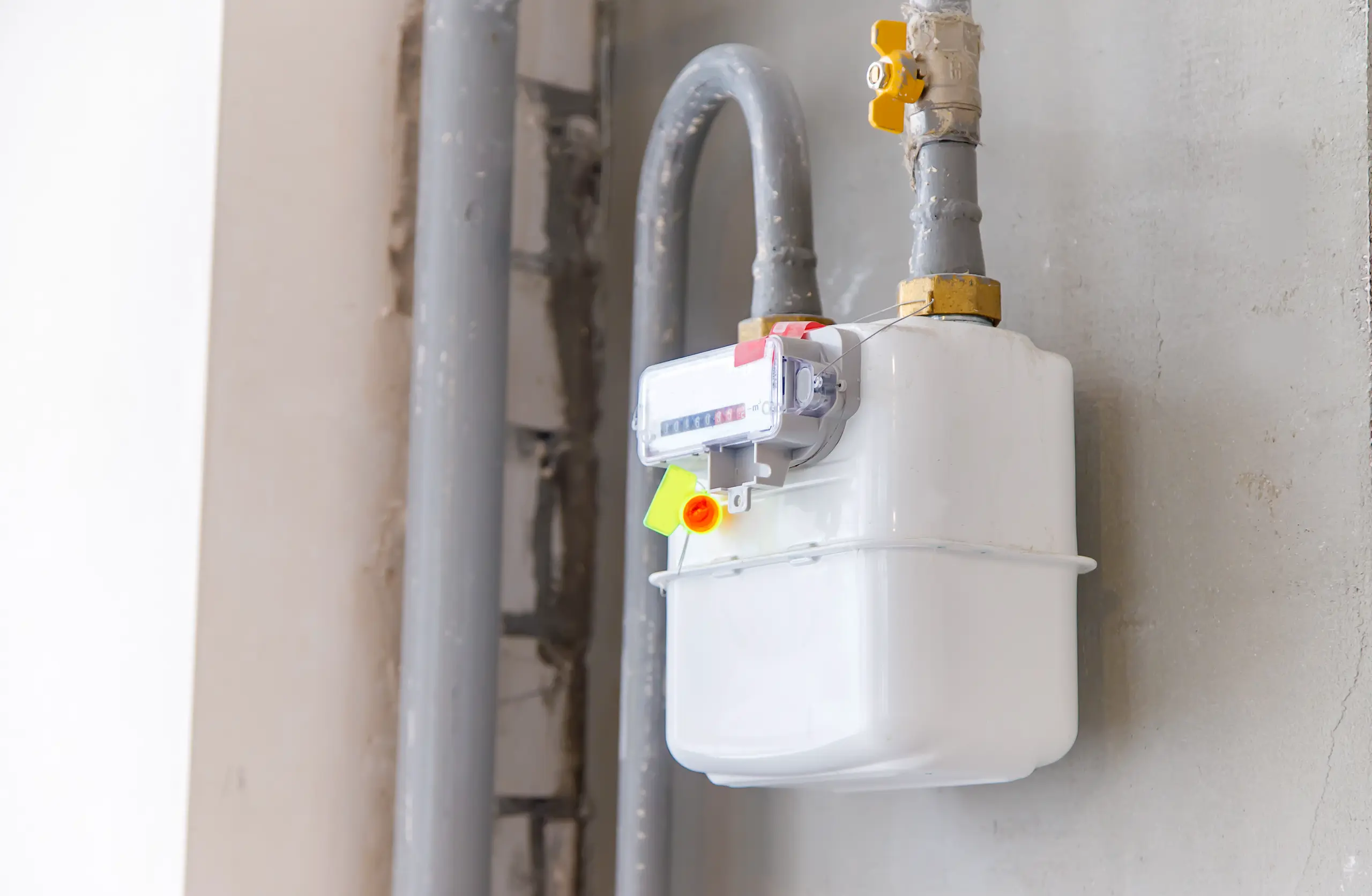Gas Meter installation on a wall with plumbing pipes