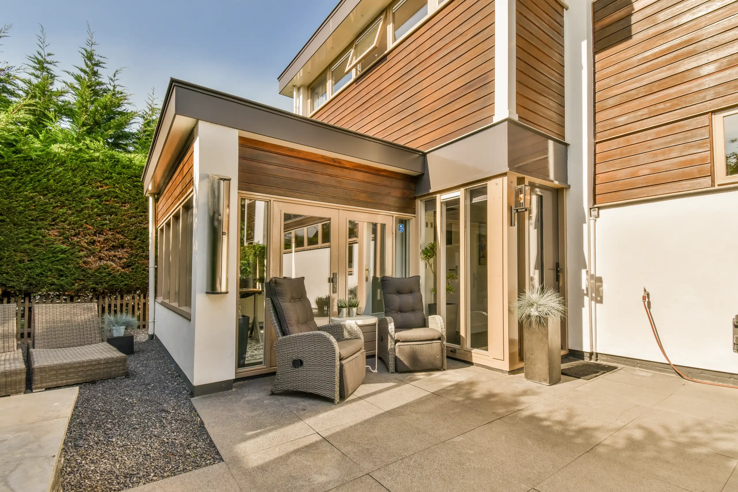 Modern home extension featuring a glass facade and outdoor seating area