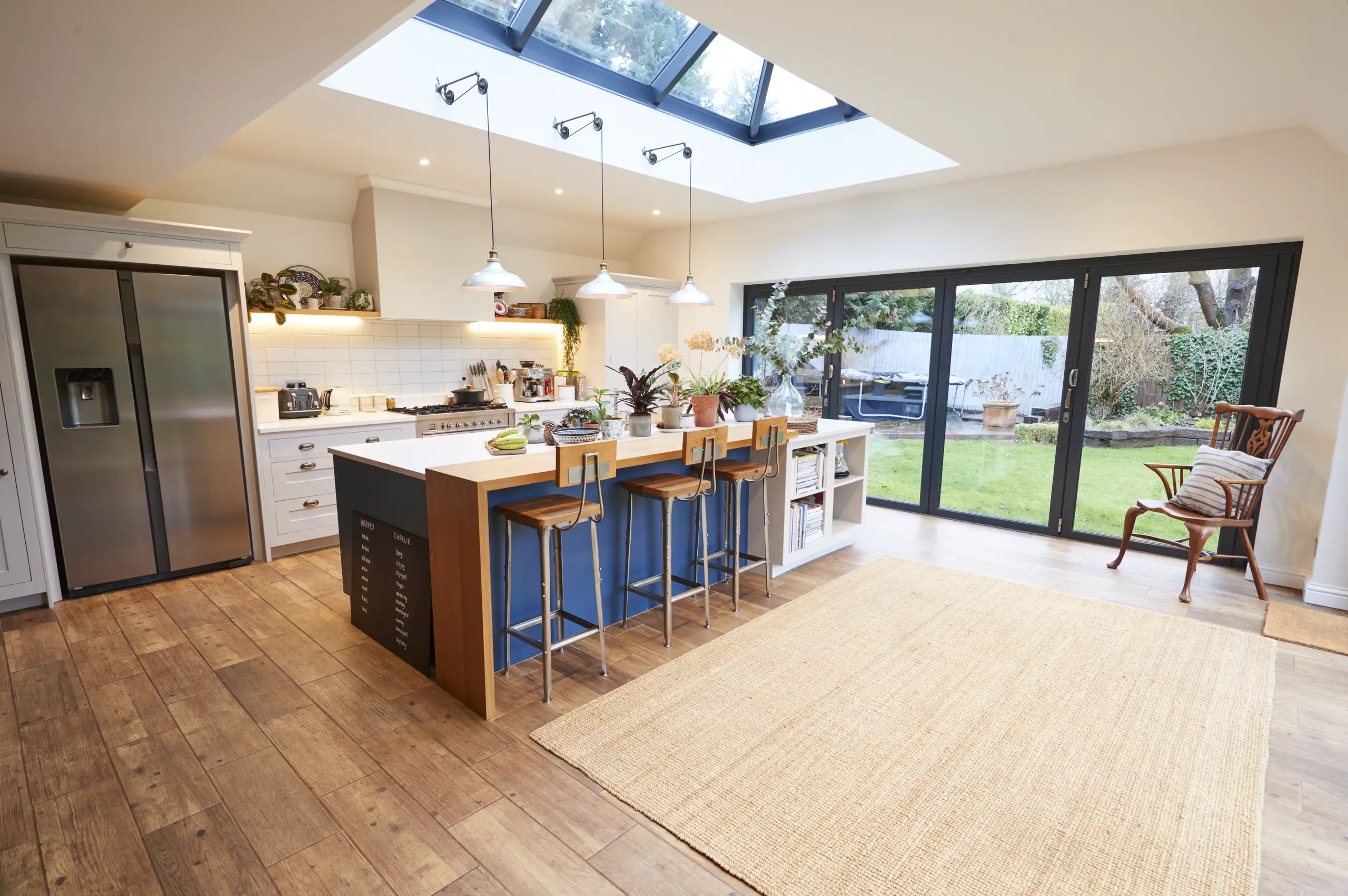 Modern kitchen refurbishment with a skylight, wooden flooring, and a spacious layout