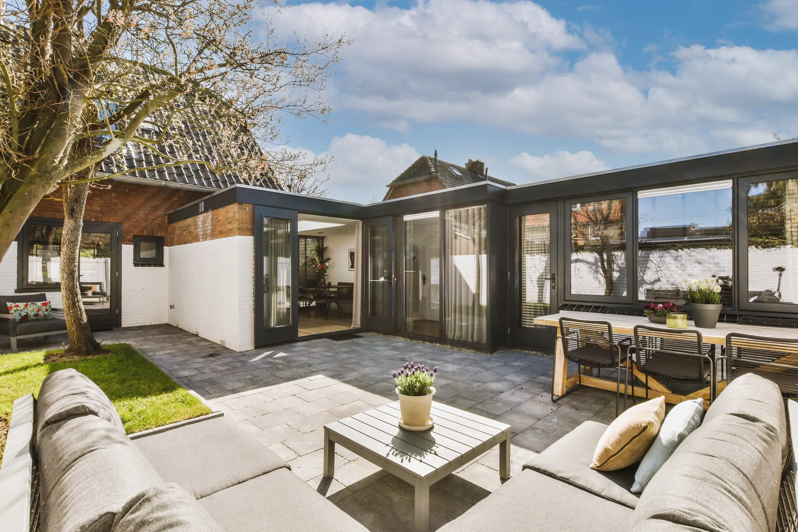Modern glass extension with outdoor seating and landscaped garden