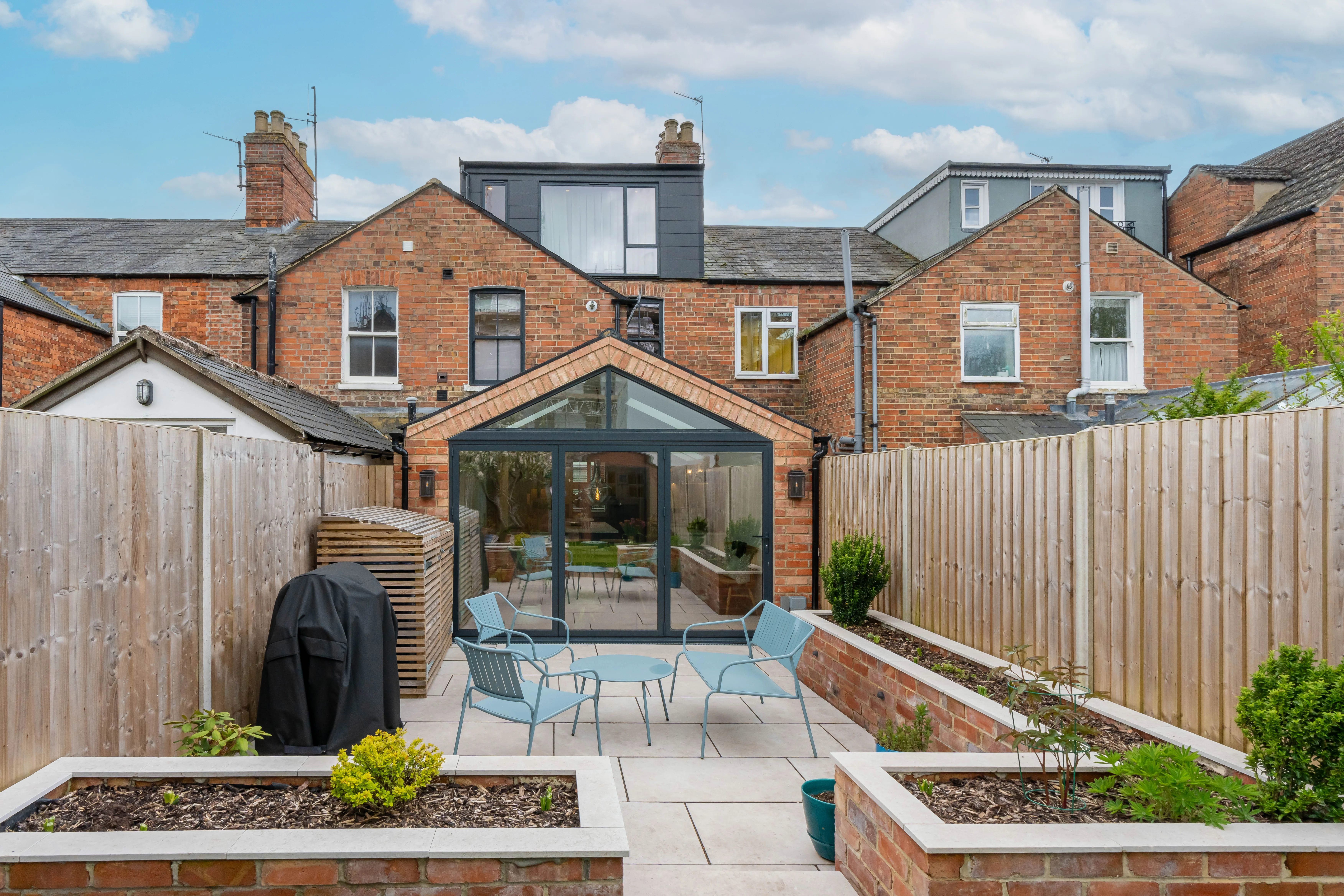 Modern glass roof extension with outdoor seating area and garden space