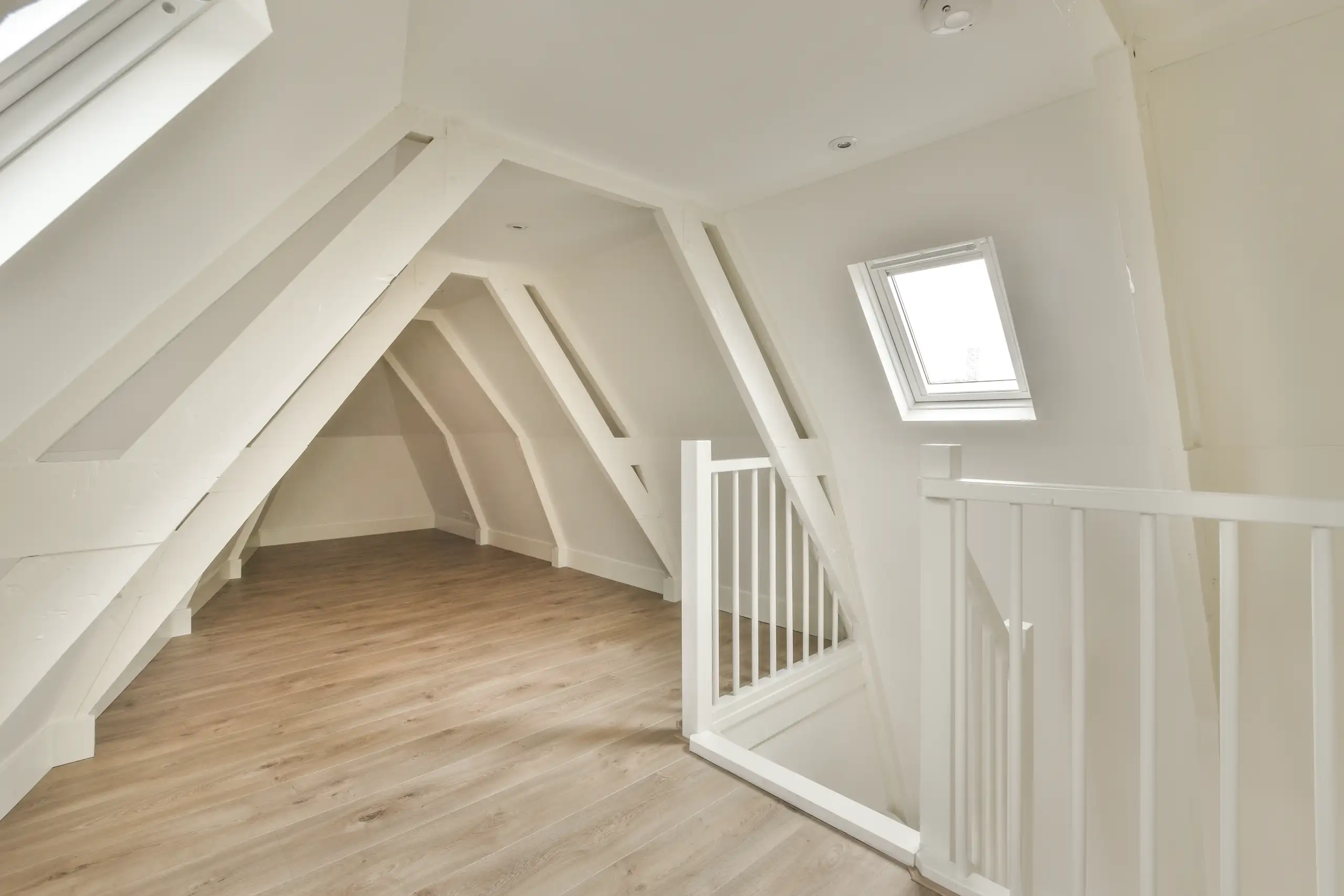 Bright loft conversion with sloped ceiling and wooden flooring, ready for furnishings