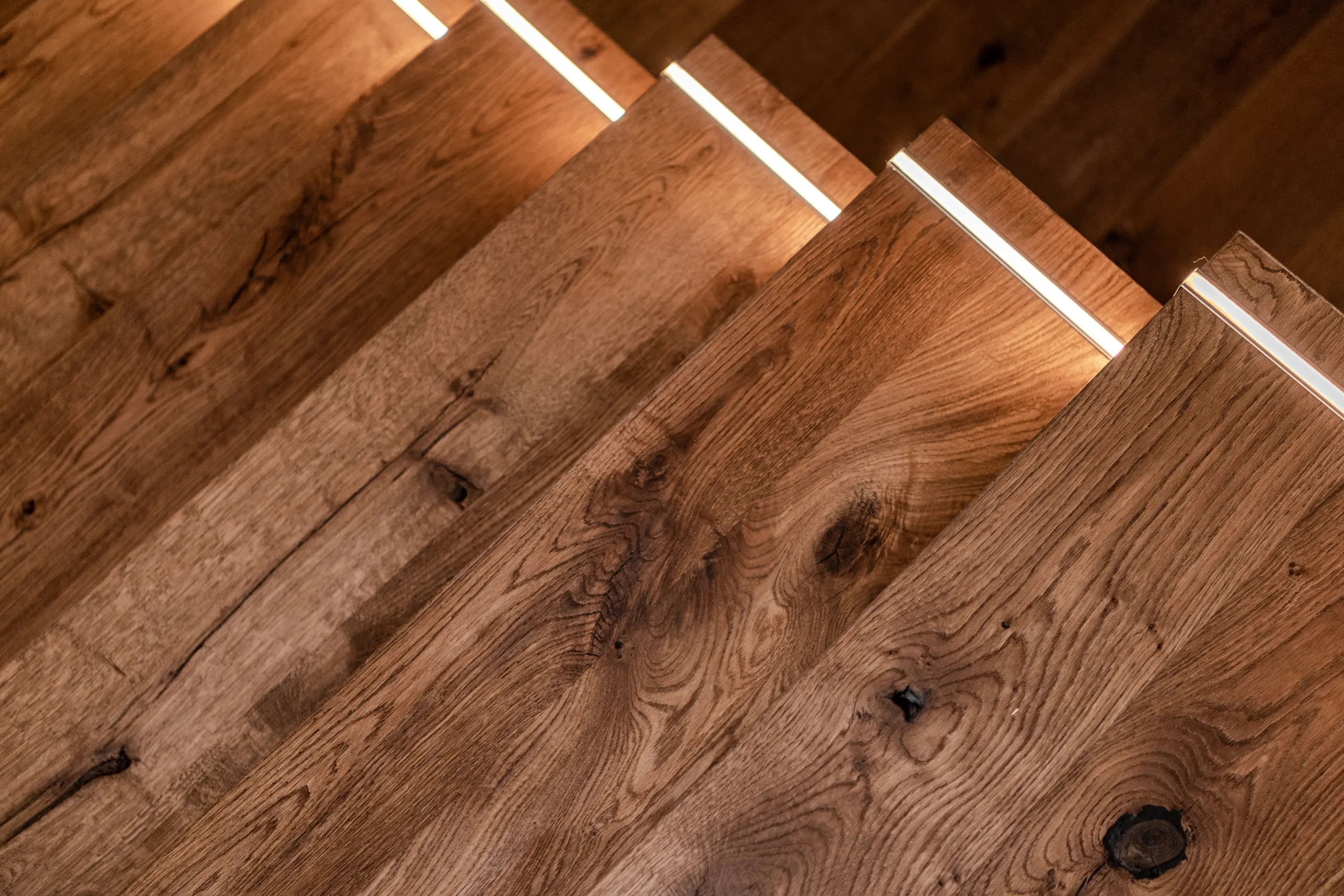 Close-up of polished oak stairs with integrated lighting