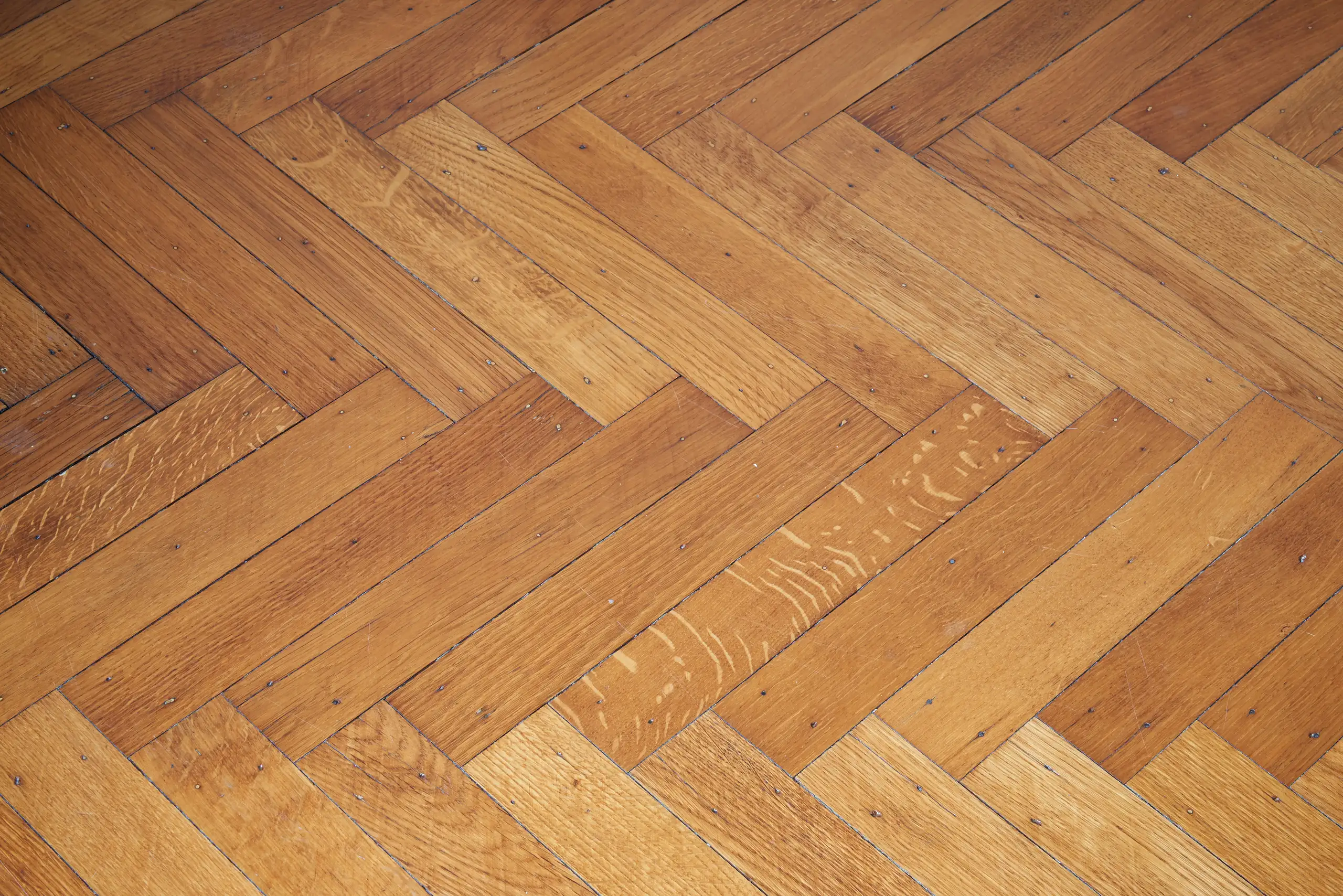 Close-up of herringbone parquet flooring showcasing quality craftsmanship