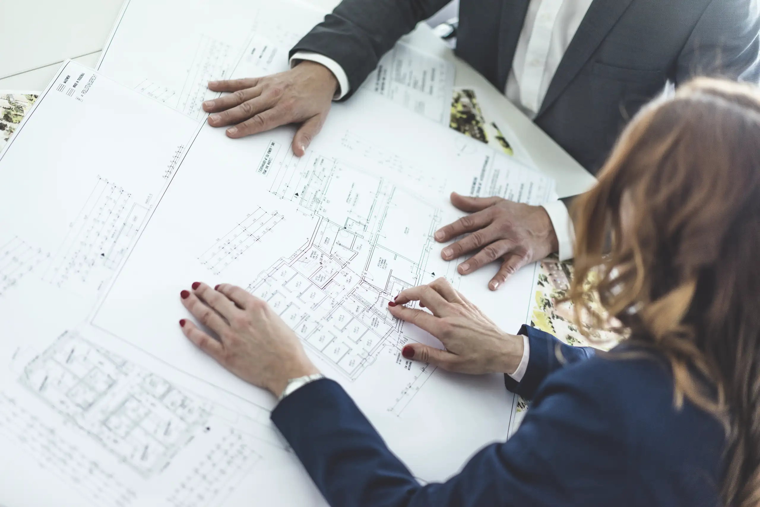 Two professionals discussing architectural plans for home refurbishment projects