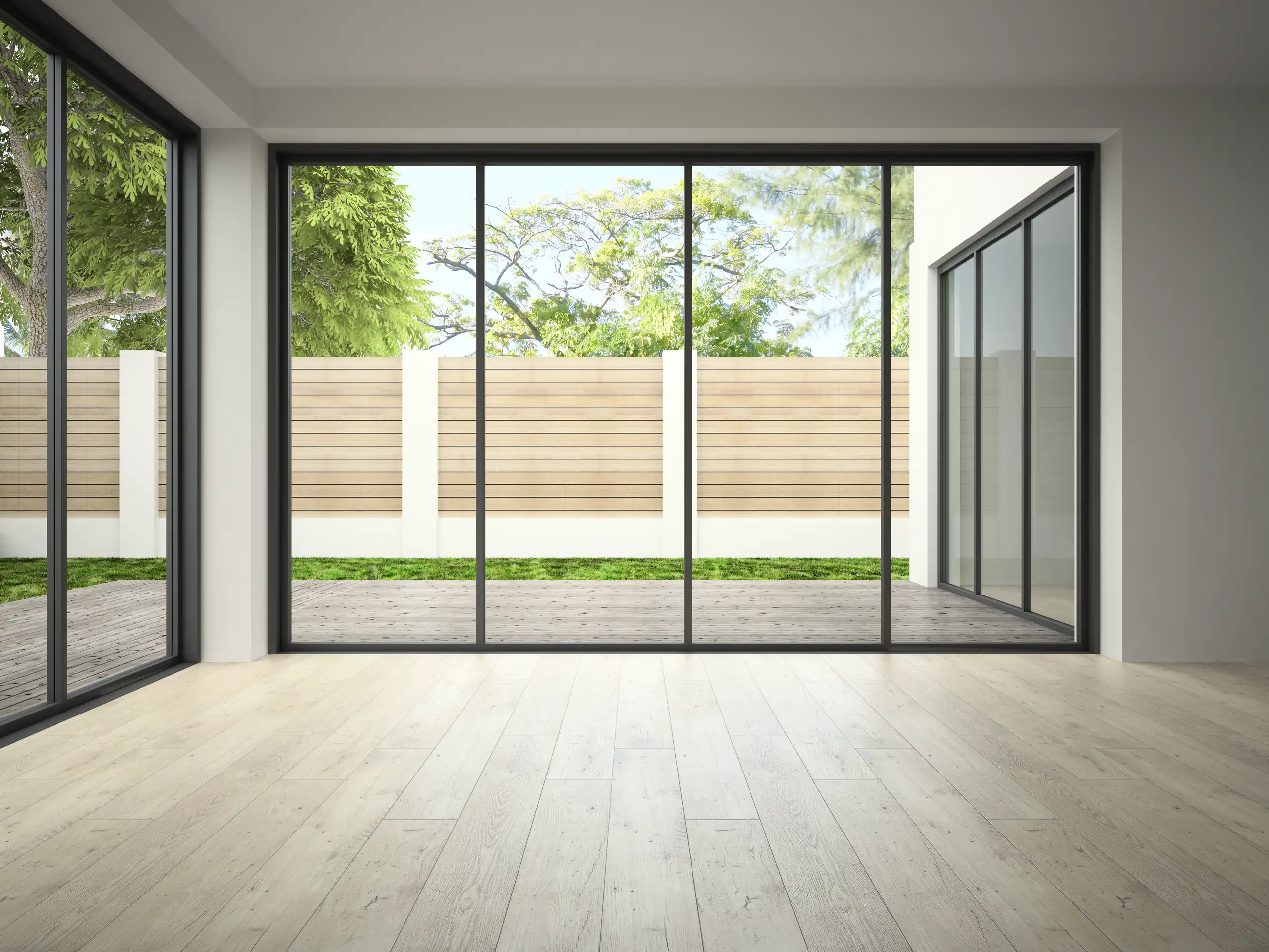 Modern interior with large glass doors leading to an outdoor area and wooden flooring