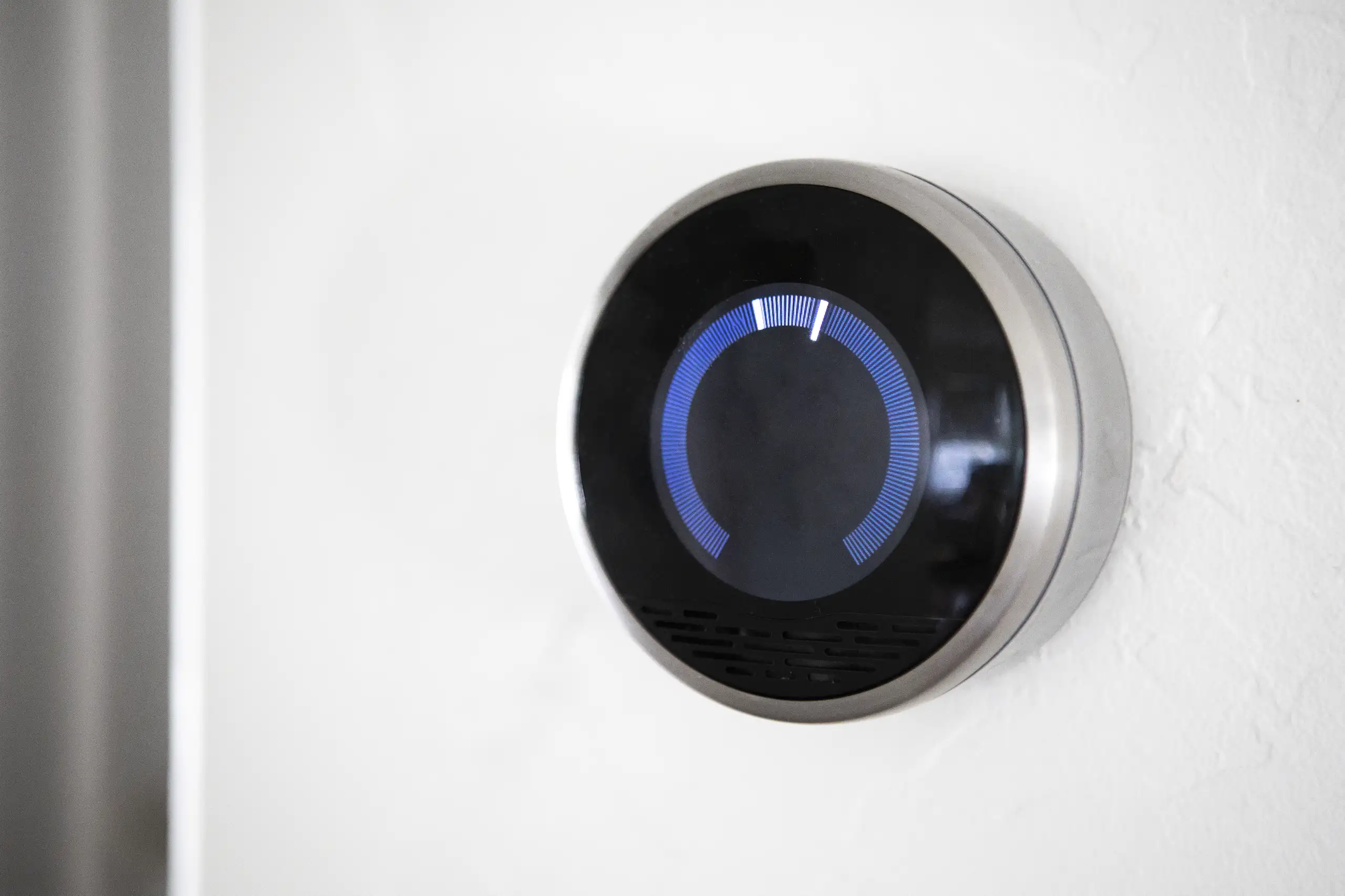 Smart home thermostat on a wall, indicating temperature control settings