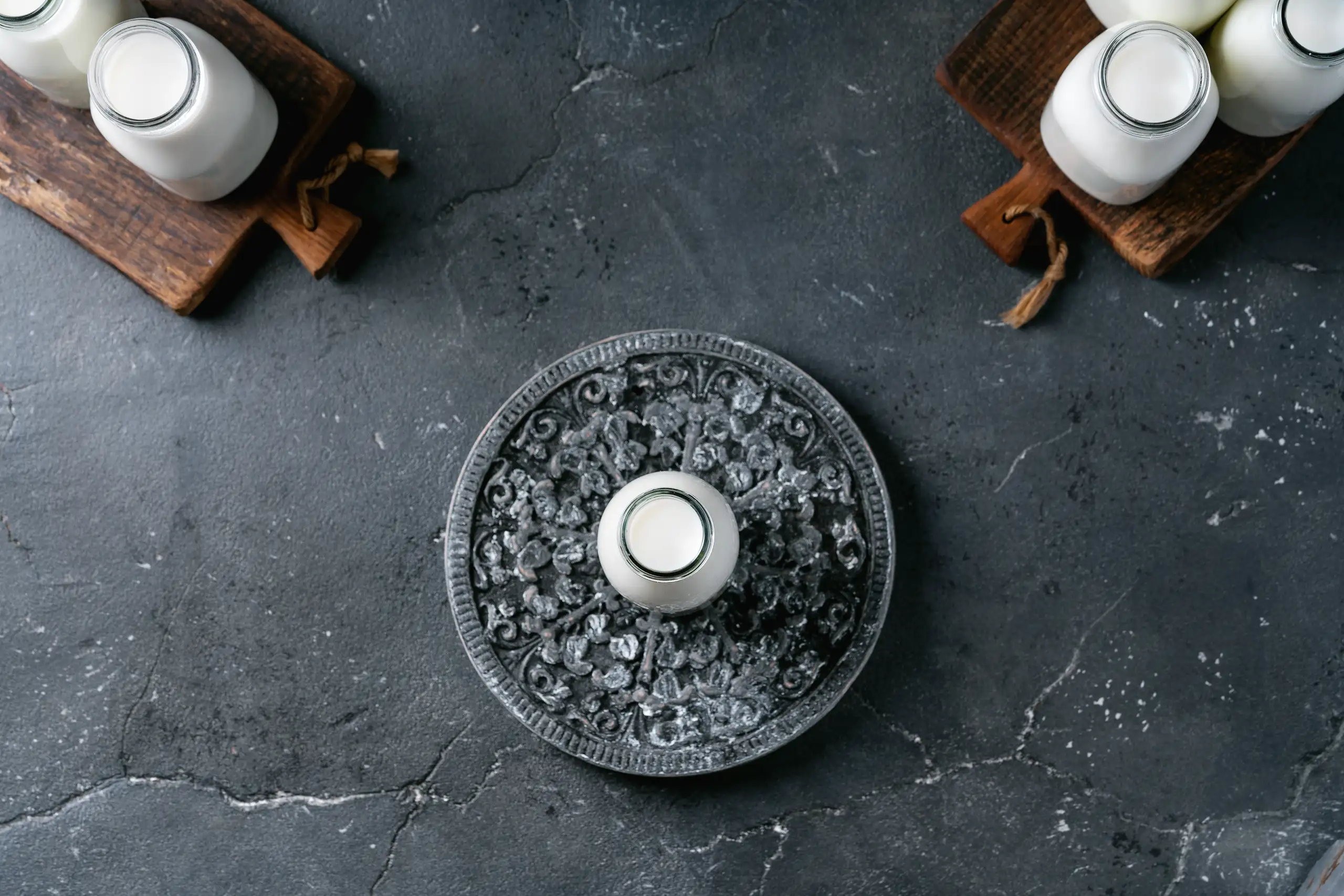 A decorative plate with a central glass jar surrounded by wooden boards with jars on them