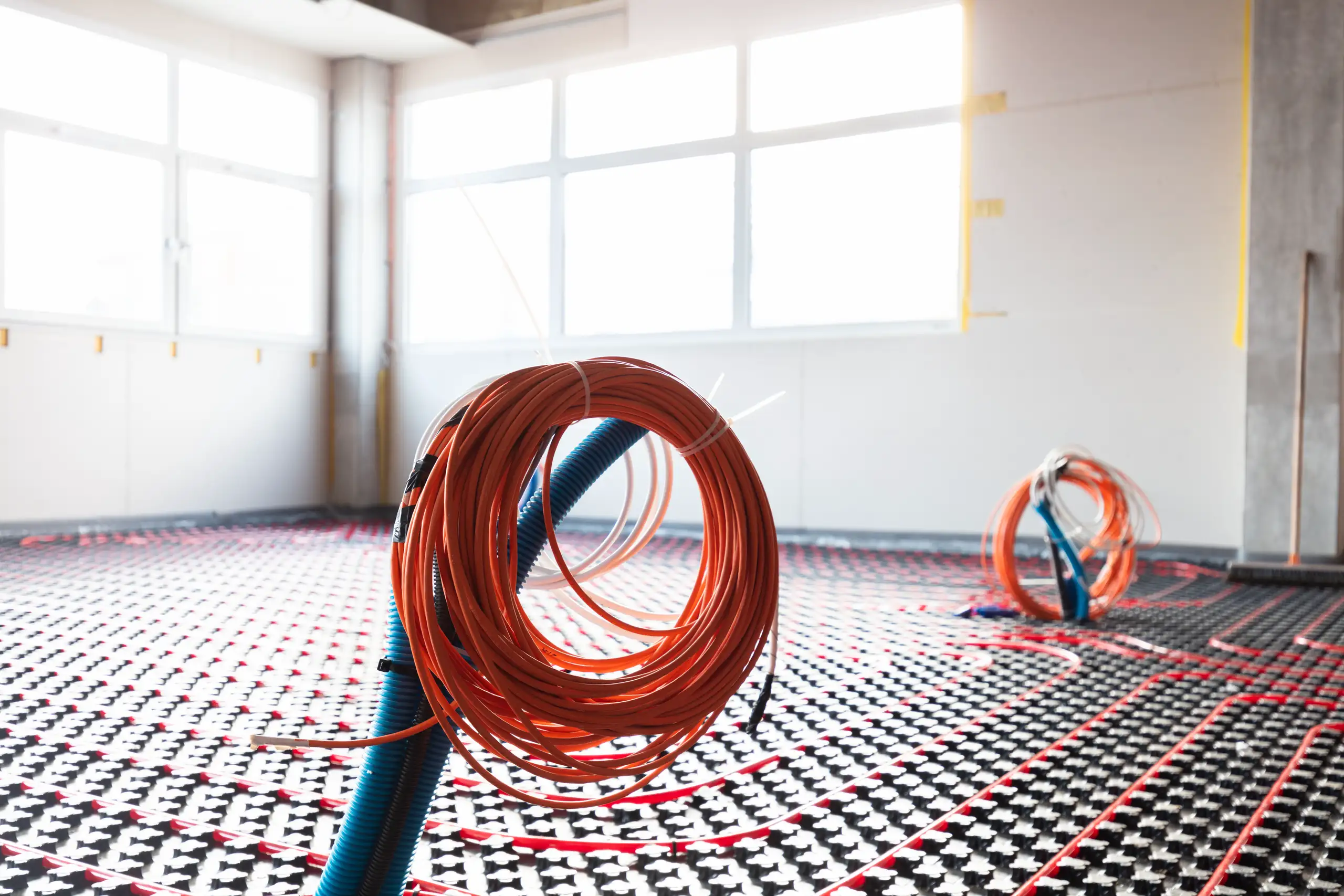 Underfloor heating installation with coiled pipes on the floor in a modern space