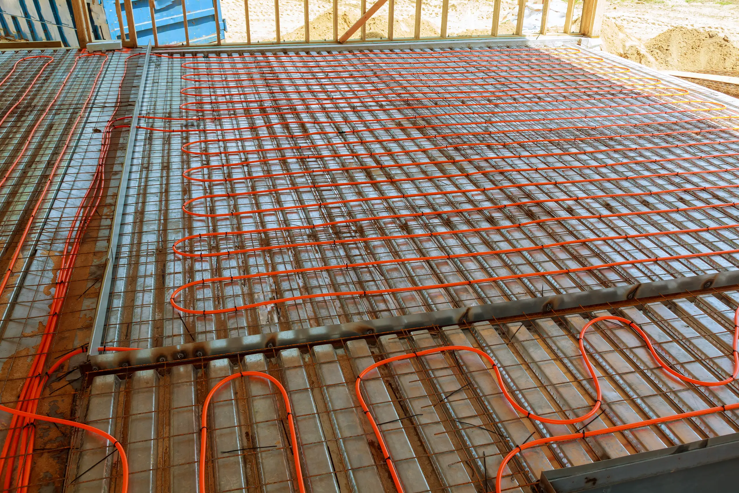 Underfloor heating installation with orange tubing laid out on the floor