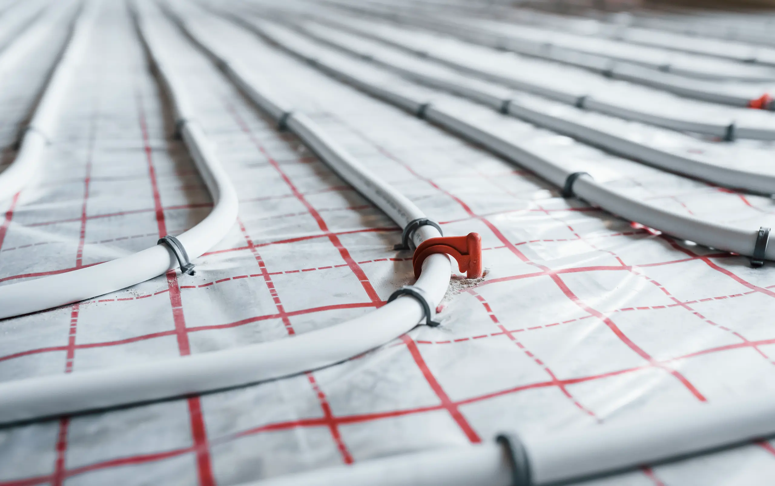 Underfloor heating installation with pipes laid out in a grid pattern
