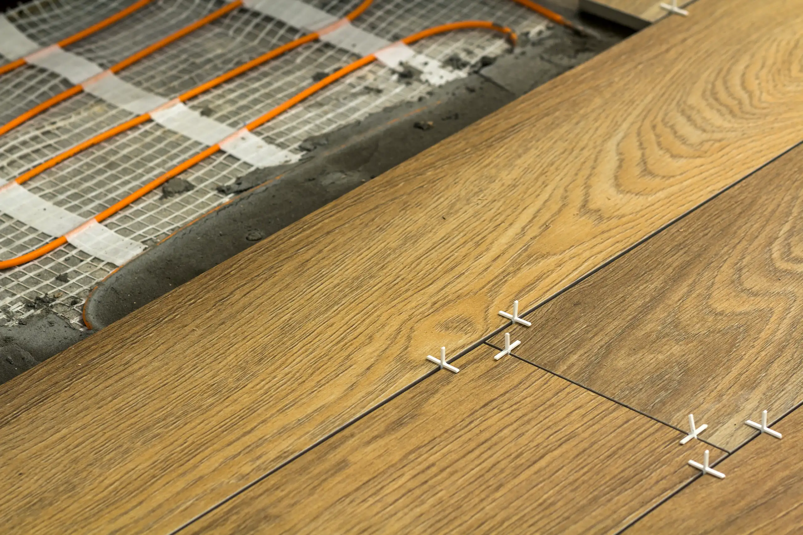 Installation of wood flooring with underfloor heating system visible below